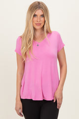 woman wearing a vibrant pink short sleeve top with a v-neckline and relaxed fit