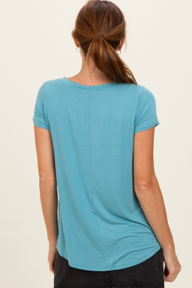 woman wearing a teal short sleeve top with a curved hem and a relaxed fit, viewed from the back