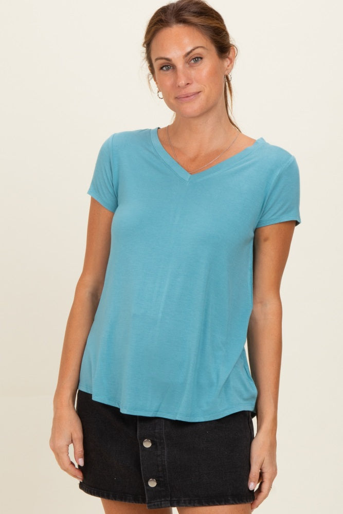 woman wearing a teal short sleeve v-neck top paired with a black denim skirt