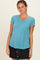woman wearing a teal short sleeve v-neck top paired with a black denim skirt