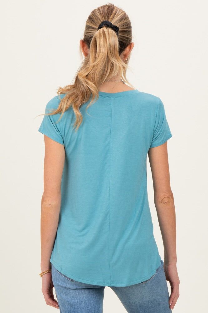 woman wearing a teal short sleeve maternity top, shown from the back with a curved hemline