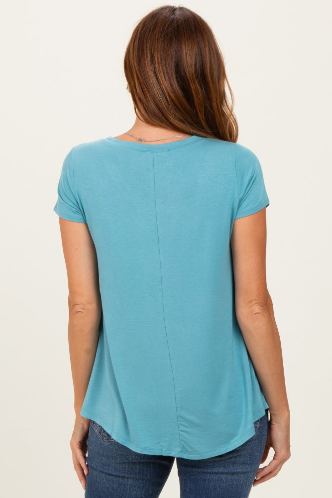 woman wearing a light blue short sleeve top with a curved hem and back seam detail, viewed from the back