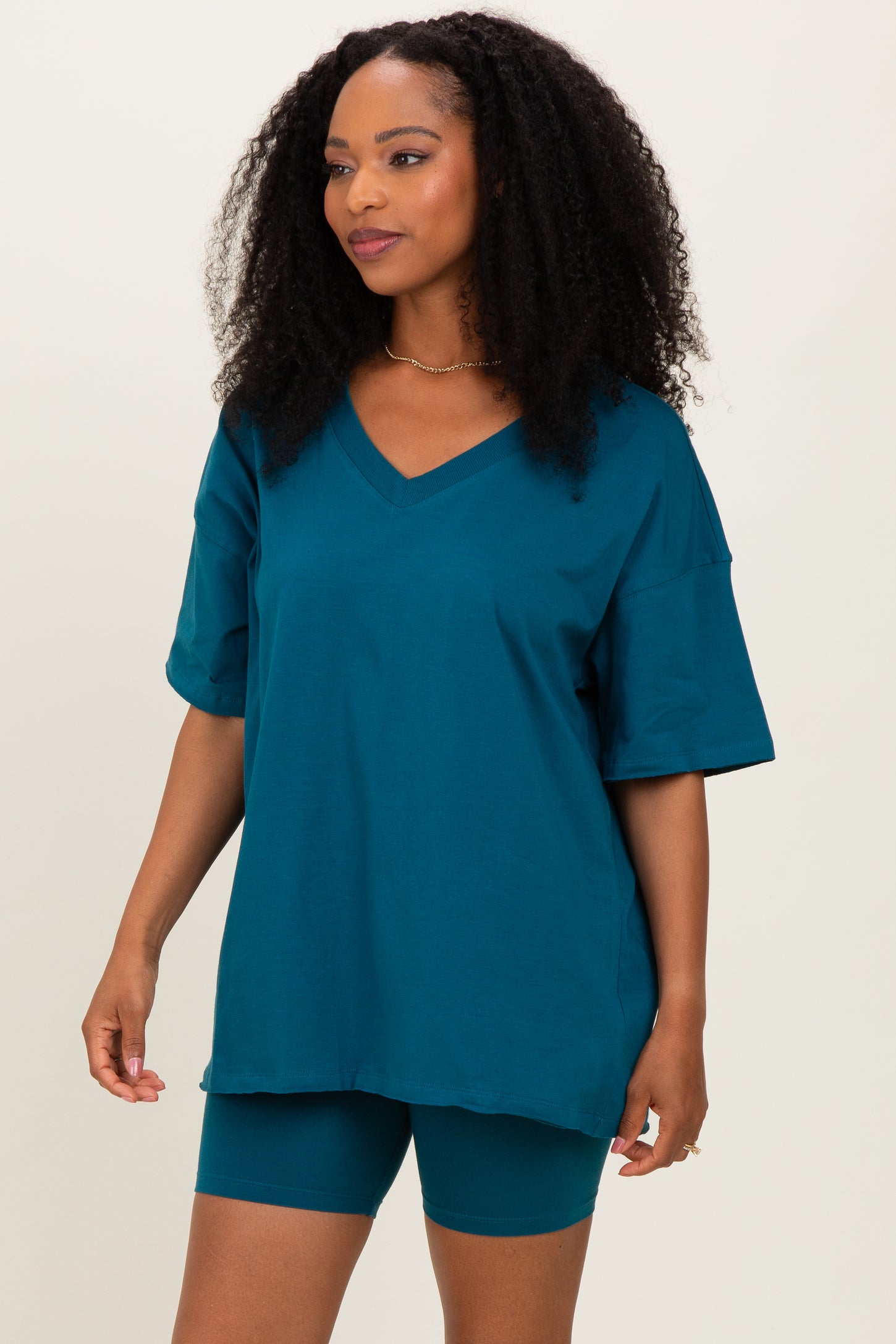 woman wearing a teal oversized v-neck t-shirt and matching bike shorts
