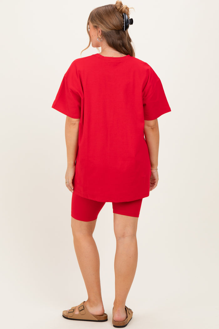 woman wearing a red maternity tunic top with matching shorts, showing a baby bump from behind