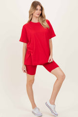 woman wearing a red oversized t-shirt and red bike shorts, styled with white sneakers