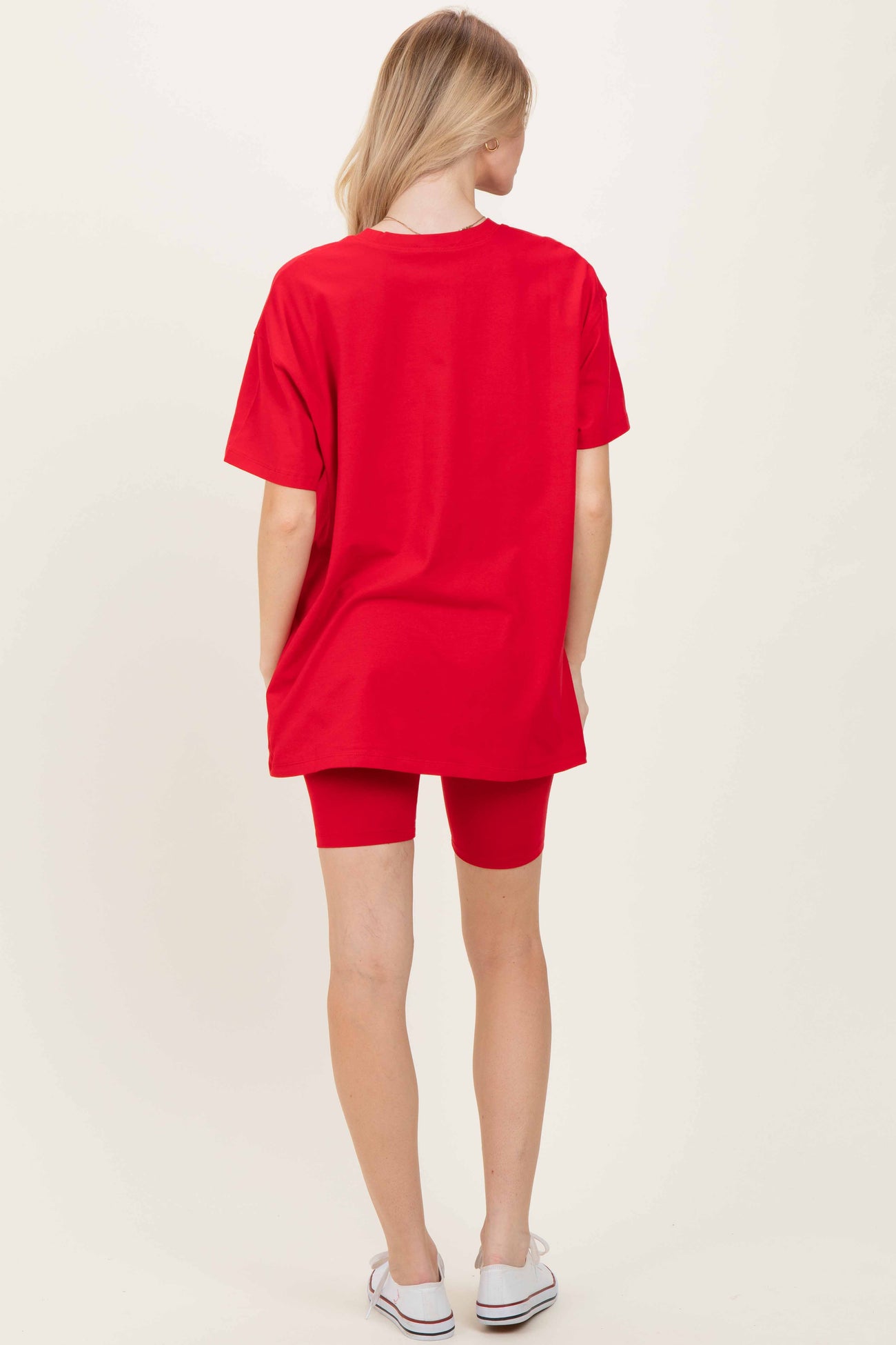woman wearing a bright red oversized t-shirt and matching red bike shorts, viewed from the back