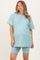 woman wearing a light blue maternity t-shirt and matching biker shorts with a visible baby bump