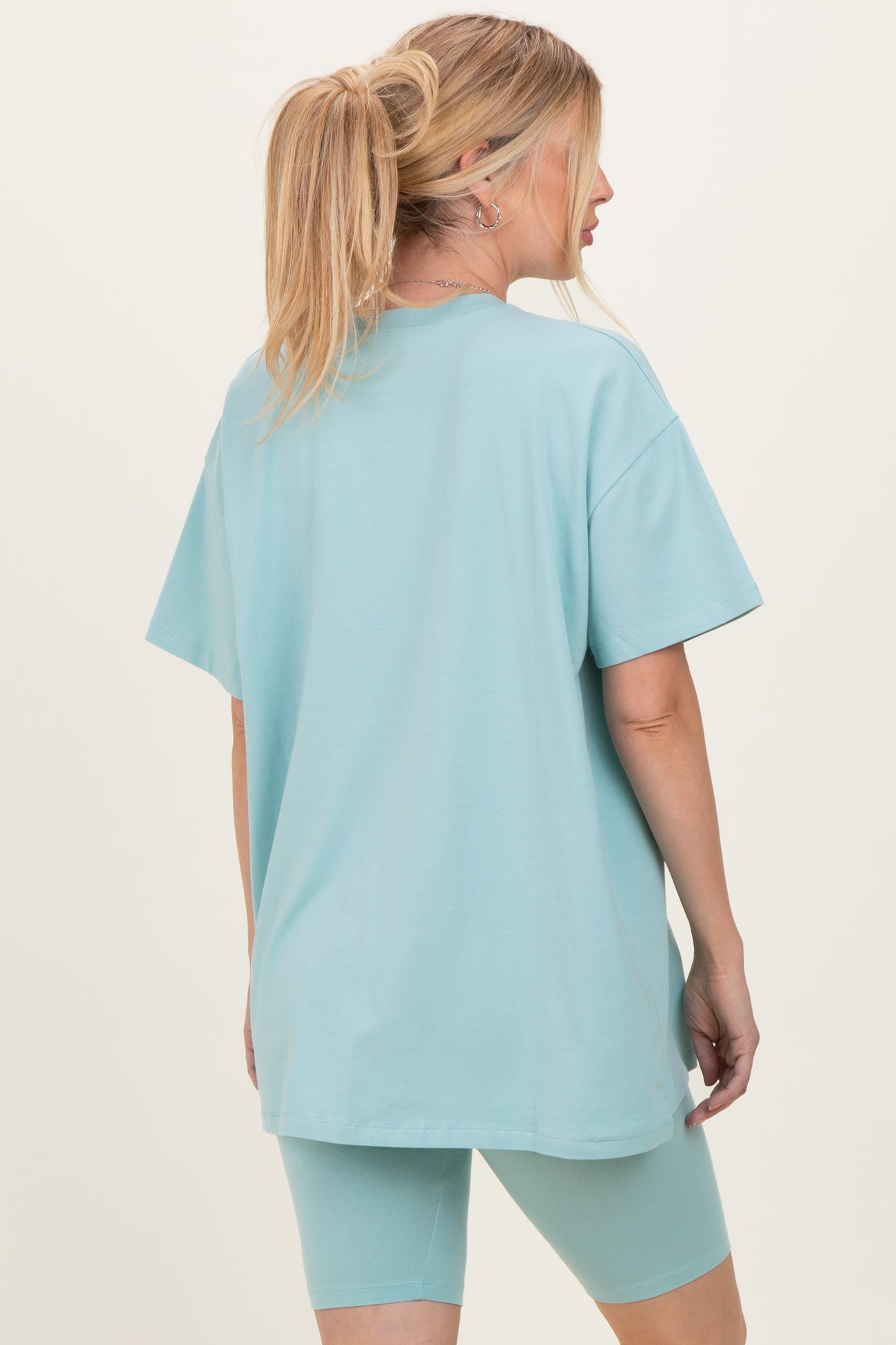 woman wearing a light blue oversized t-shirt and matching bike shorts, viewed from the back