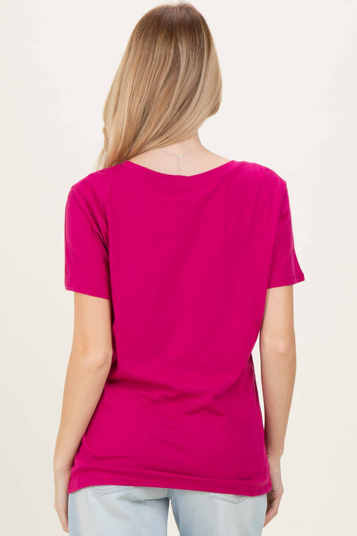 woman wearing a bright pink short sleeve t-shirt, viewed from the back with long blonde hair down