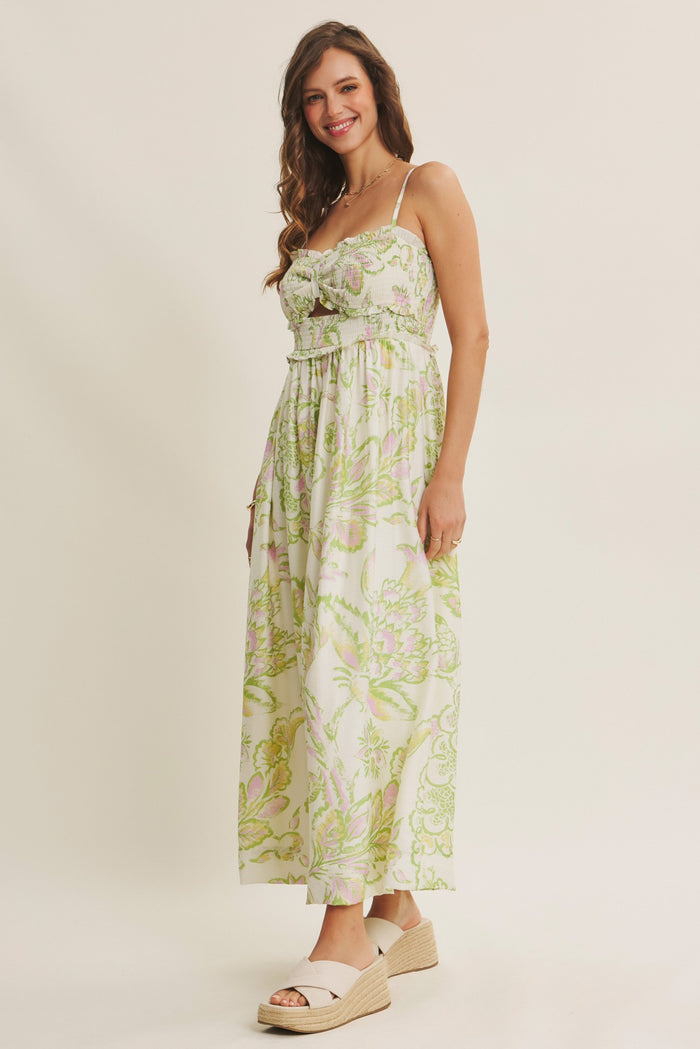 woman wearing a floral maxi dress with green and pink patterns and white espadrille sandals