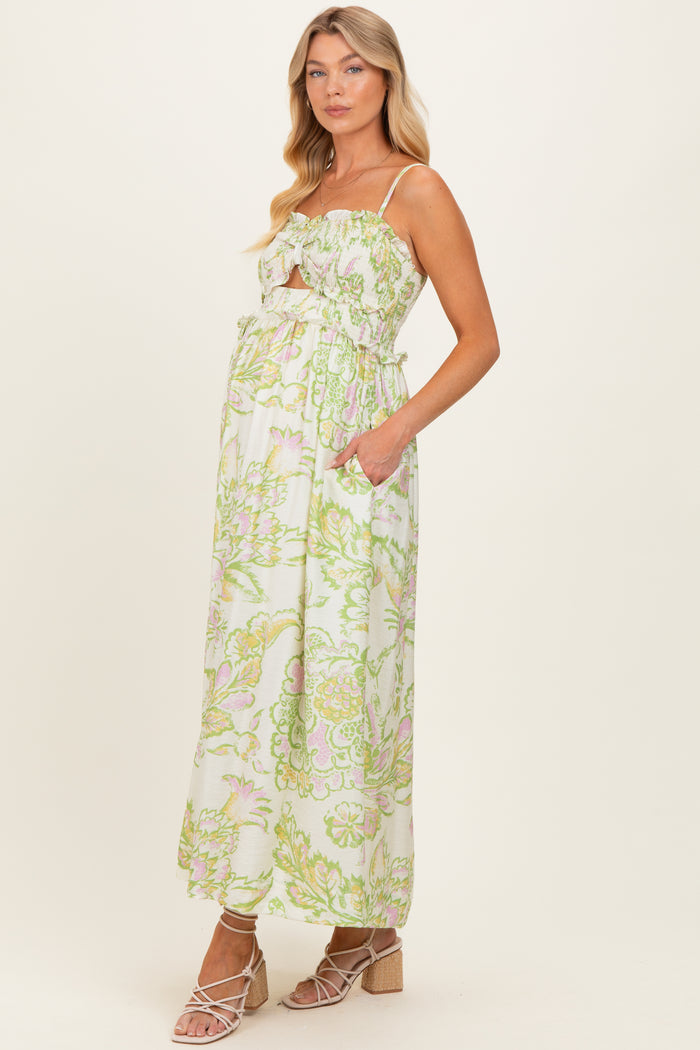 woman wearing a floral maternity maxi dress with a sweetheart neckline and pockets, showcasing her baby bump