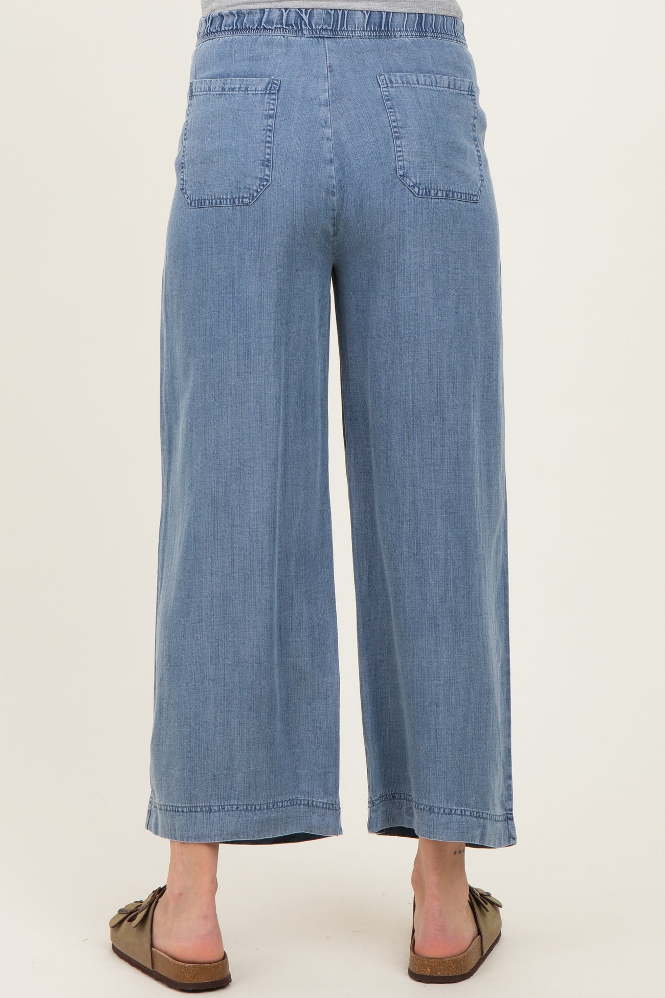 woman wearing blue maternity culotte jeans with an elastic waistband, view from the back