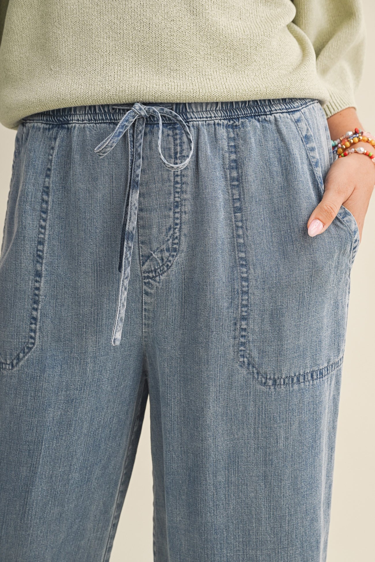 woman wearing light blue drawstring wide-leg pants with side pockets and a comfortable fit
