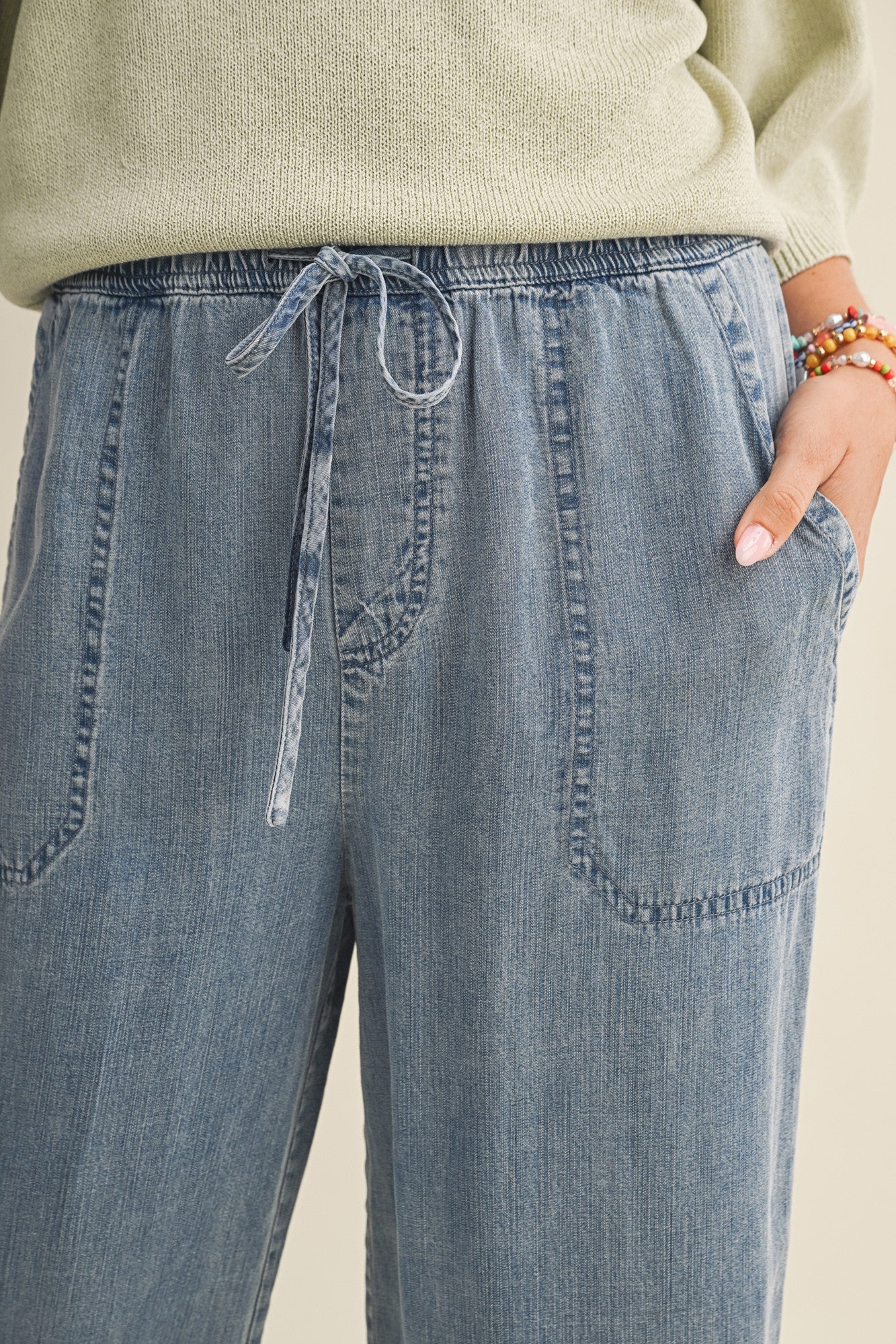 woman wearing light blue drawstring wide-leg pants with side pockets and a comfortable fit