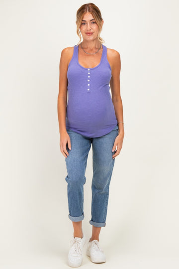 woman wearing a purple maternity tank top with buttons and blue rolled cuff jeans, showcasing her baby bump