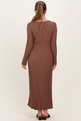woman wearing a brown ribbed maternity maxi dress with long sleeves, showing a fitted silhouette from the back