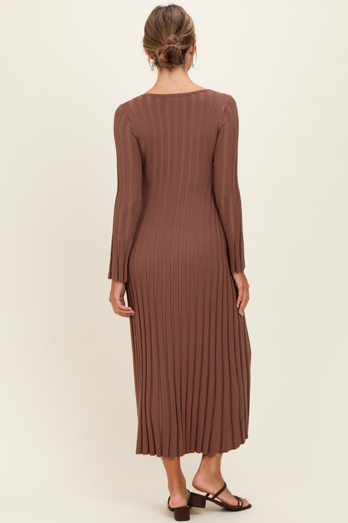 woman wearing a long brown ribbed knit dress with long sleeves and a flared hem, seen from the back