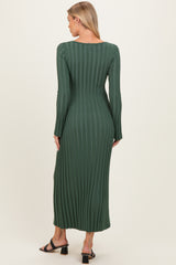 woman wearing a dark green maternity ribbed maxi dress with long sleeves and a fitted silhouette