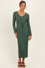 woman wearing a long green ribbed knit maxi dress with a v-neck and belt detail