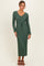 woman wearing a long green ribbed knit maxi dress with a v-neck and belt detail