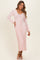 woman wearing a pink ribbed long sleeve midi dress with a v-neck and tie waist detail