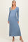 woman wearing a light blue ribbed maternity maxi dress with a v-neck and tie detail, showcasing her baby bump
