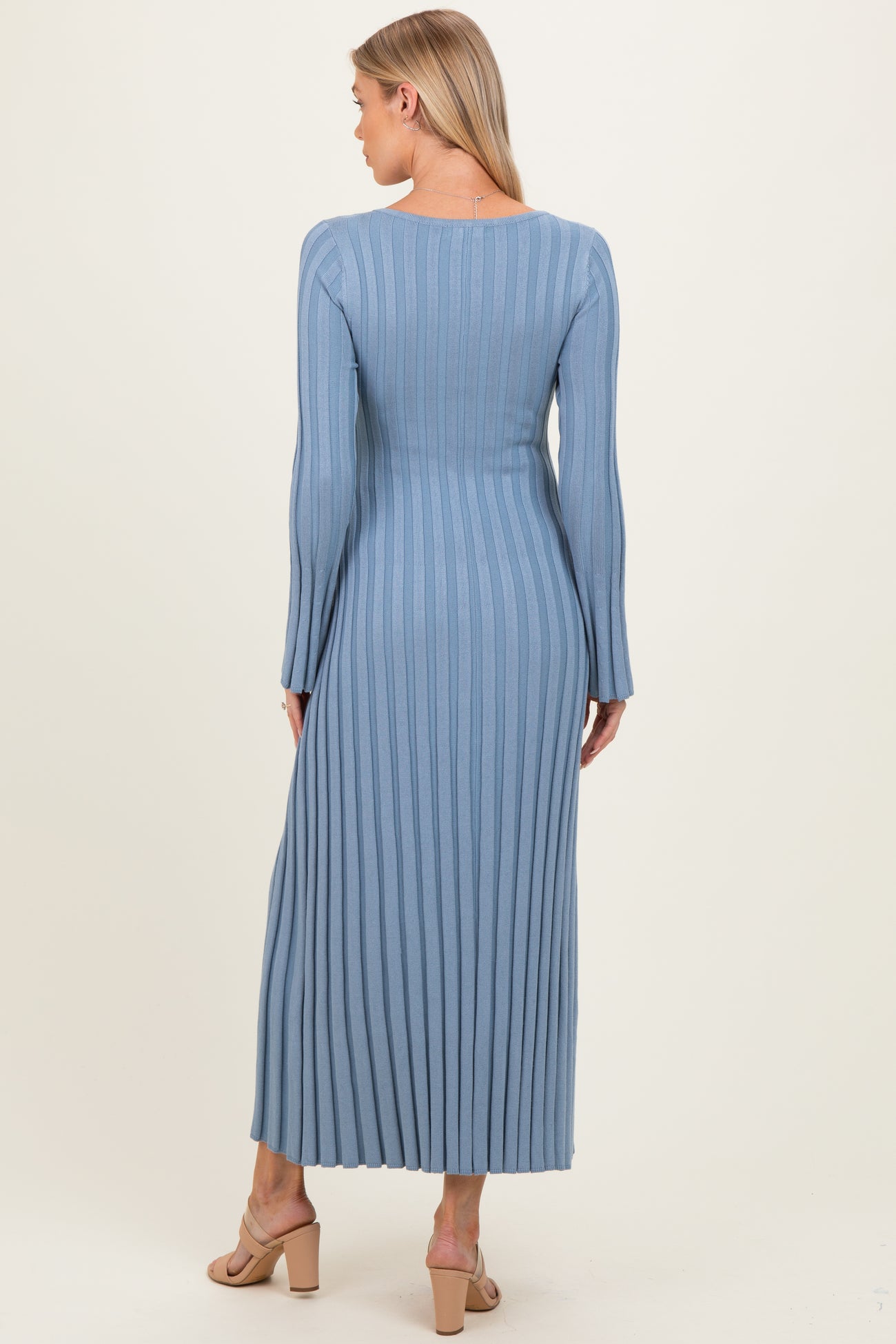 woman wearing a light blue ribbed maternity dress with long sleeves and a fitted silhouette