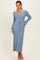 woman wearing a light blue ribbed maxi dress with a v-neckline and long sleeves, featuring a tie detail at the waist