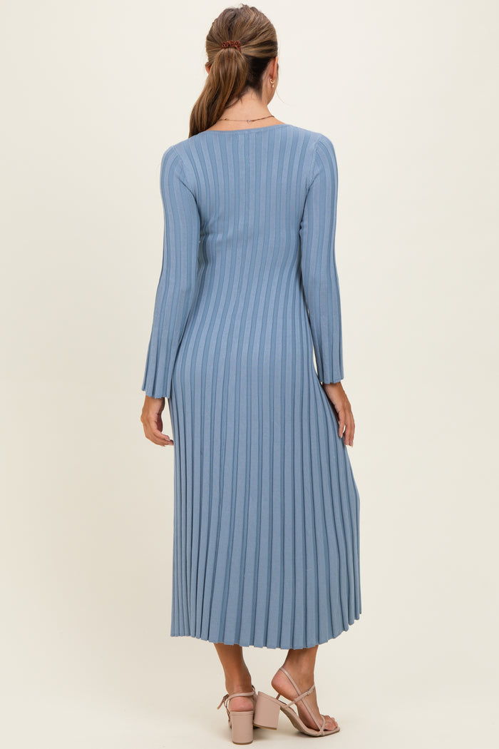woman wearing a long sleeve ribbed midi dress in light blue, showing the back view with a fitted silhouette and side pleats