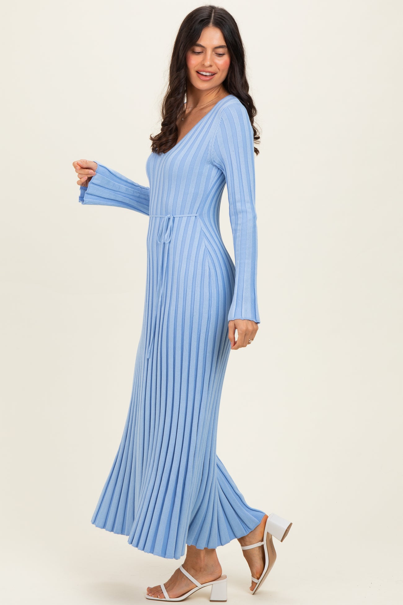 woman wearing a light blue long sleeve ribbed maxi dress with a v-neck and tie waist detail