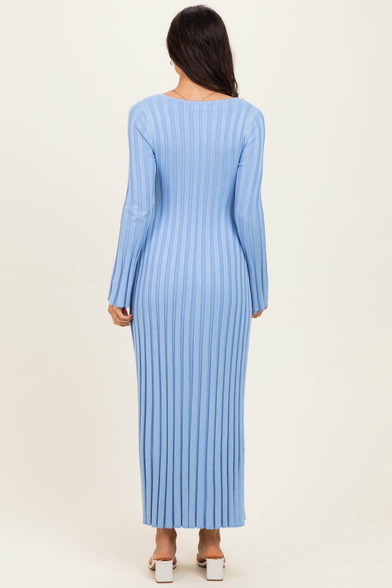 woman wearing a long sleeve light blue ribbed maxi dress, shown from the back