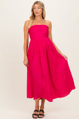 woman wearing a hot pink strapless maternity dress with vertical stripes and a flowing midi length