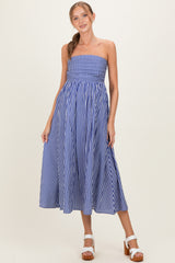 woman wearing a blue and white striped strapless maternity dress with an empire waist and flowing skirt