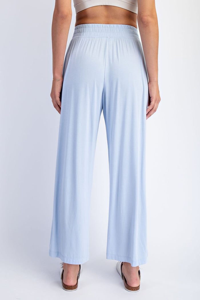 woman wearing light blue wide leg pants with an elastic waistband, shown from the back