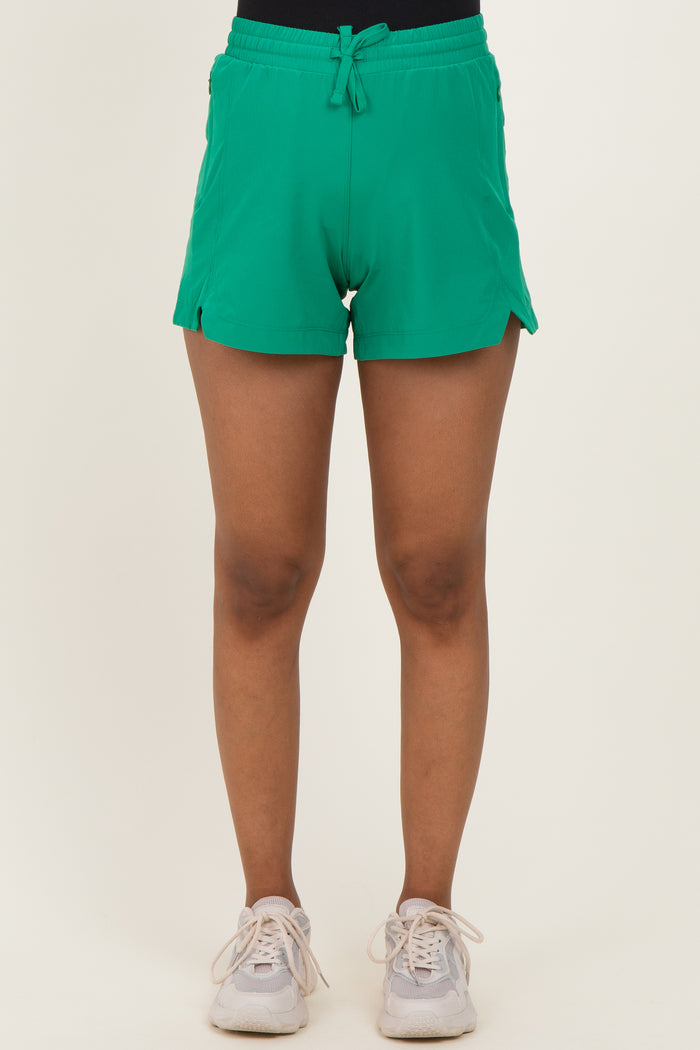 woman wearing green maternity shorts with side slits and drawstring waist