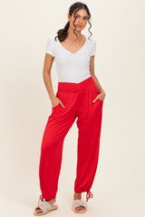 woman wearing a white short sleeve v-neck top and red jogger pants with pockets and ankle ties