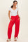woman wearing a white short sleeve v-neck top and red jogger pants with pockets and ankle ties