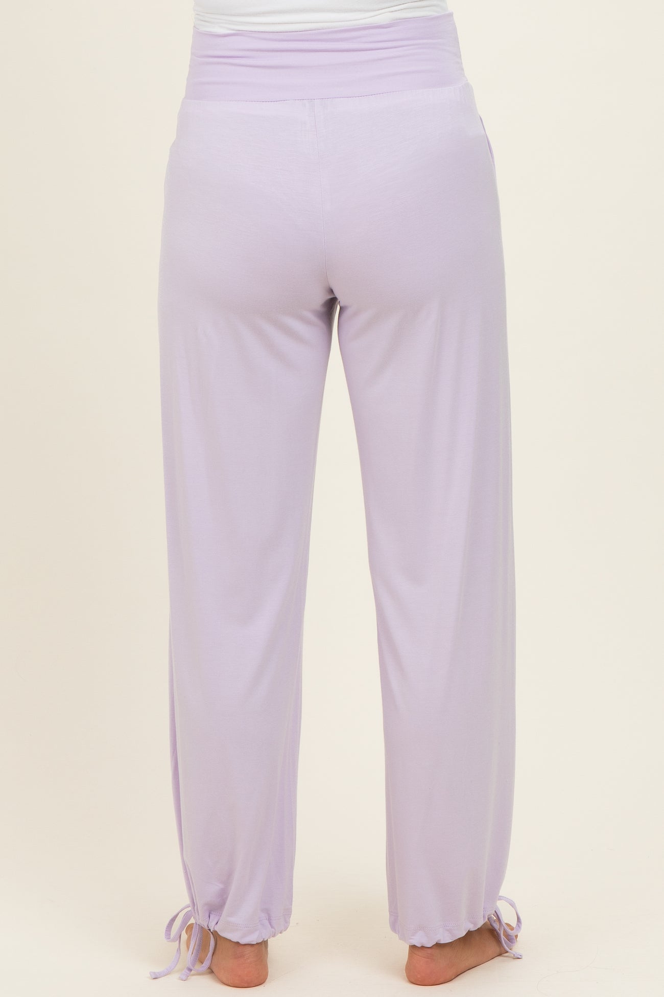 woman wearing lavender maternity pants with a drawstring at the ankles, showing the back view