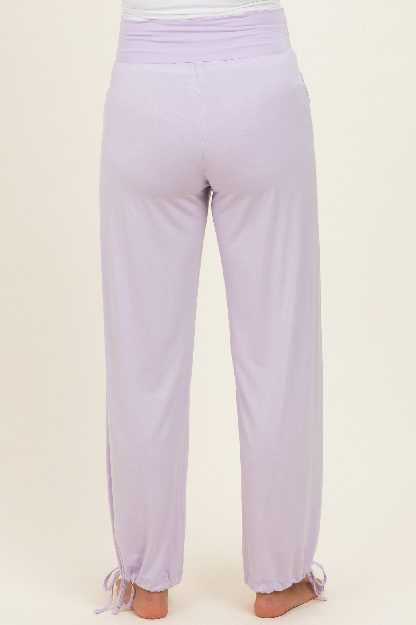 woman wearing lavender maternity pants with a drawstring at the ankles, showing the back view