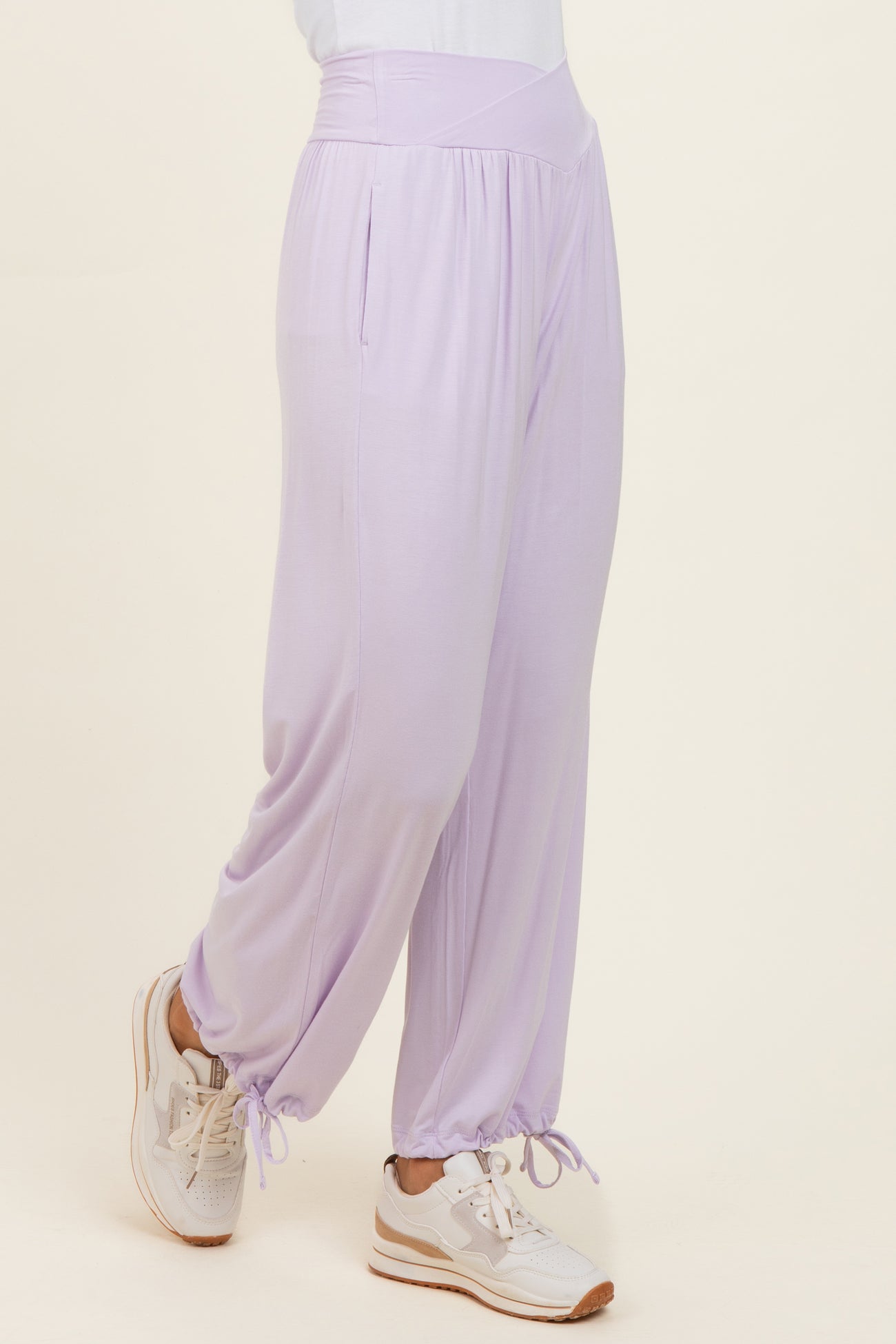 woman wearing light purple wide-leg pants with side pockets and elastic cuffs, paired with white sneakers