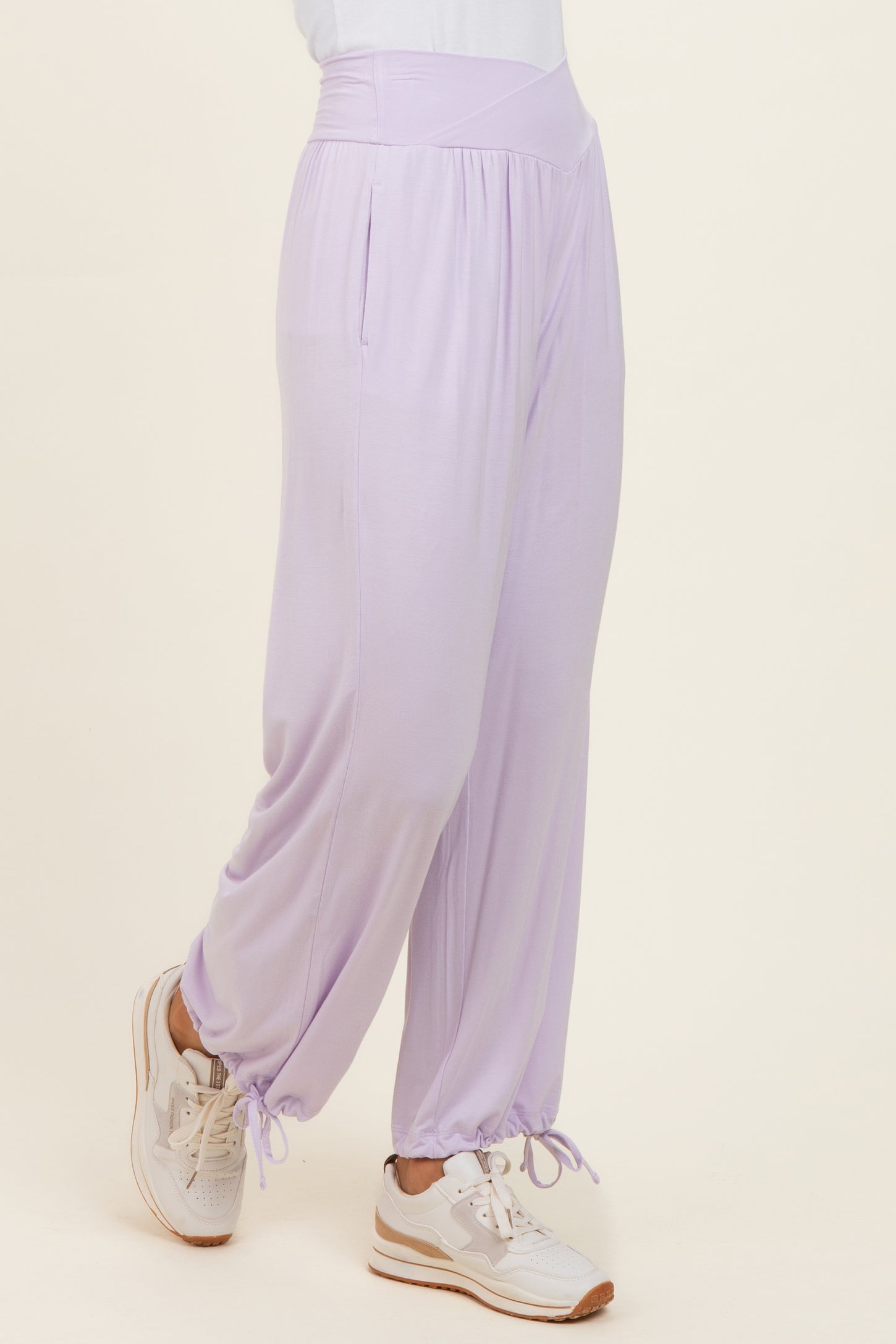 woman wearing light purple wide-leg pants with side pockets and elastic cuffs, paired with white sneakers
