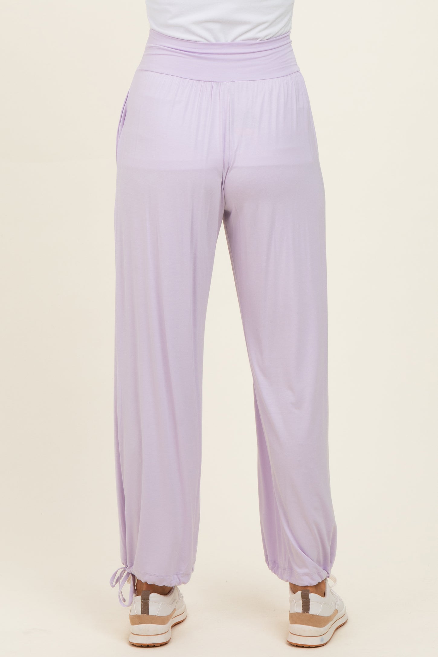 woman wearing lavender high-waisted lounge pants with elastic cuffs and drawstring detail at the ankles