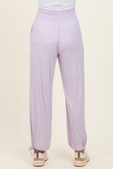 woman wearing lavender high-waisted lounge pants with elastic cuffs and drawstring detail at the ankles