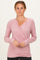 woman wearing a light pink long sleeve wrap top with a v-neck and fitted style