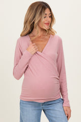 woman wearing a dusty pink maternity wrap top and showing her baby bump