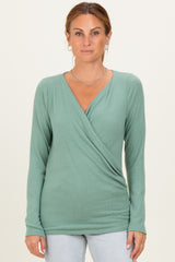 woman wearing a green long sleeve wrap top with a v-neckline and fitted style