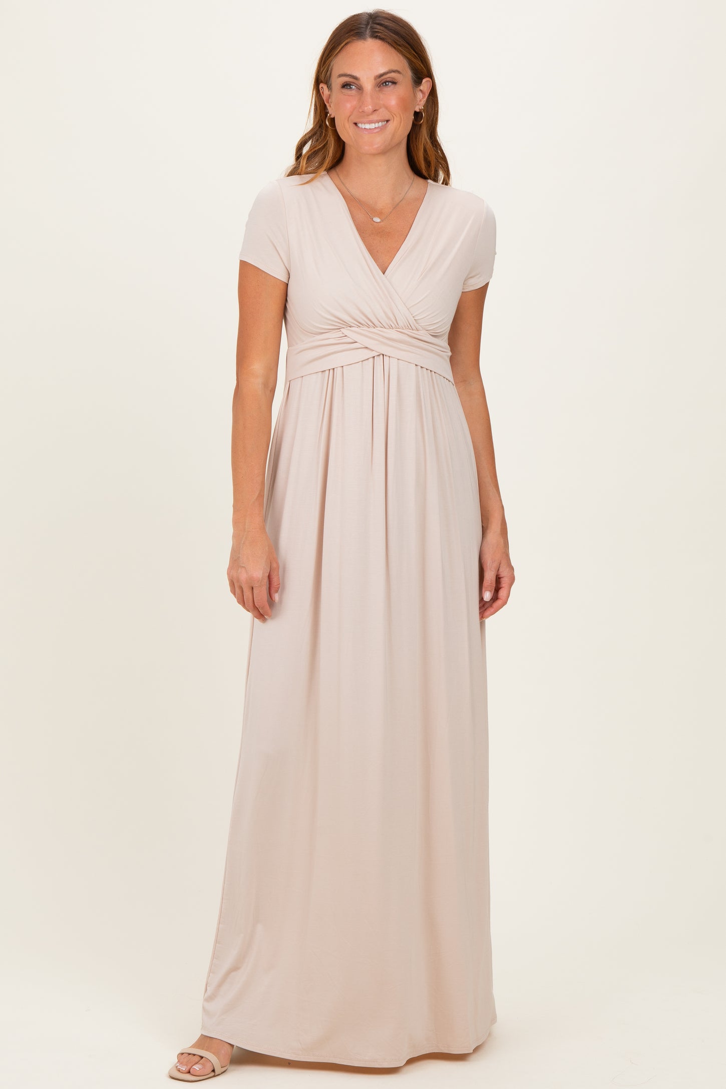 woman wearing a light beige short sleeve maxi dress with a wrap front and empire waist