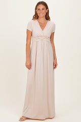 woman wearing a light beige short sleeve maxi dress with a wrap front and empire waist