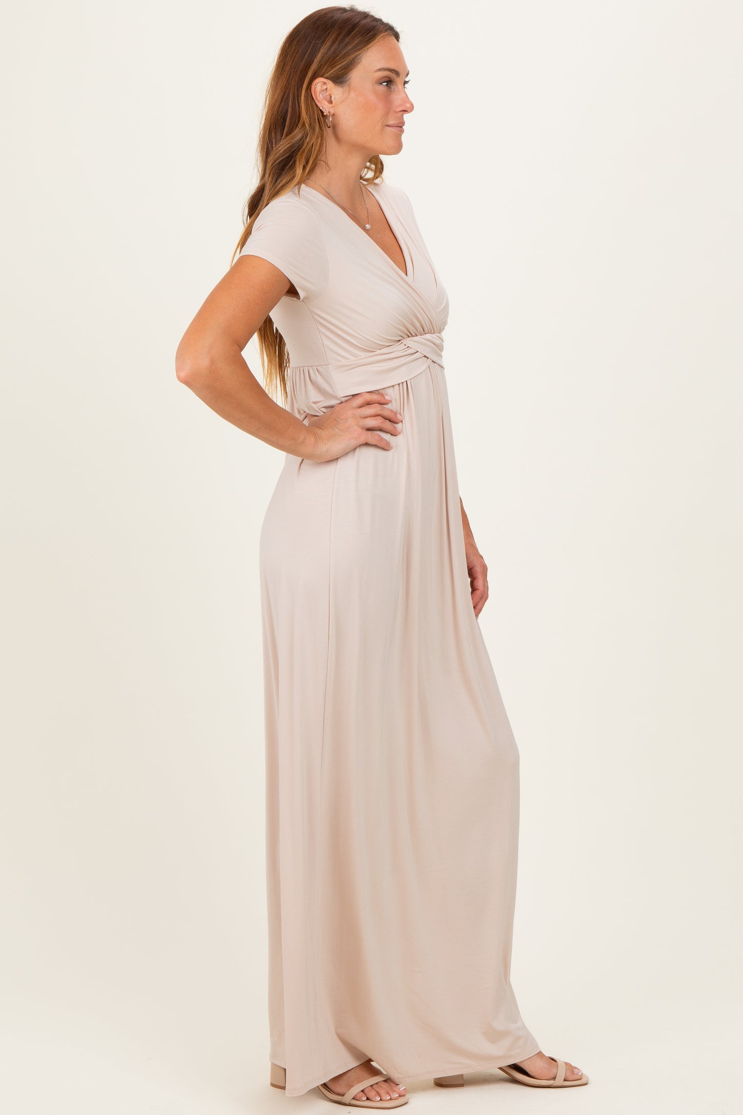 woman wearing a light beige short sleeve maxi dress with a knot detail at the waist