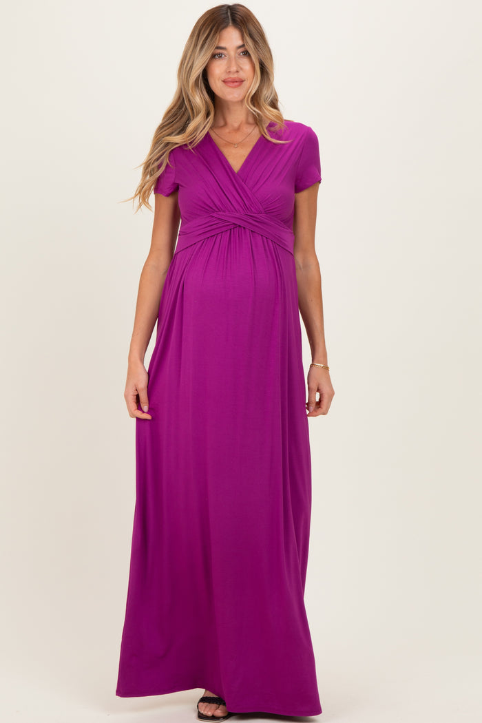 woman wearing a vibrant purple short sleeve maternity maxi dress with a gathered waist and baby bump visible